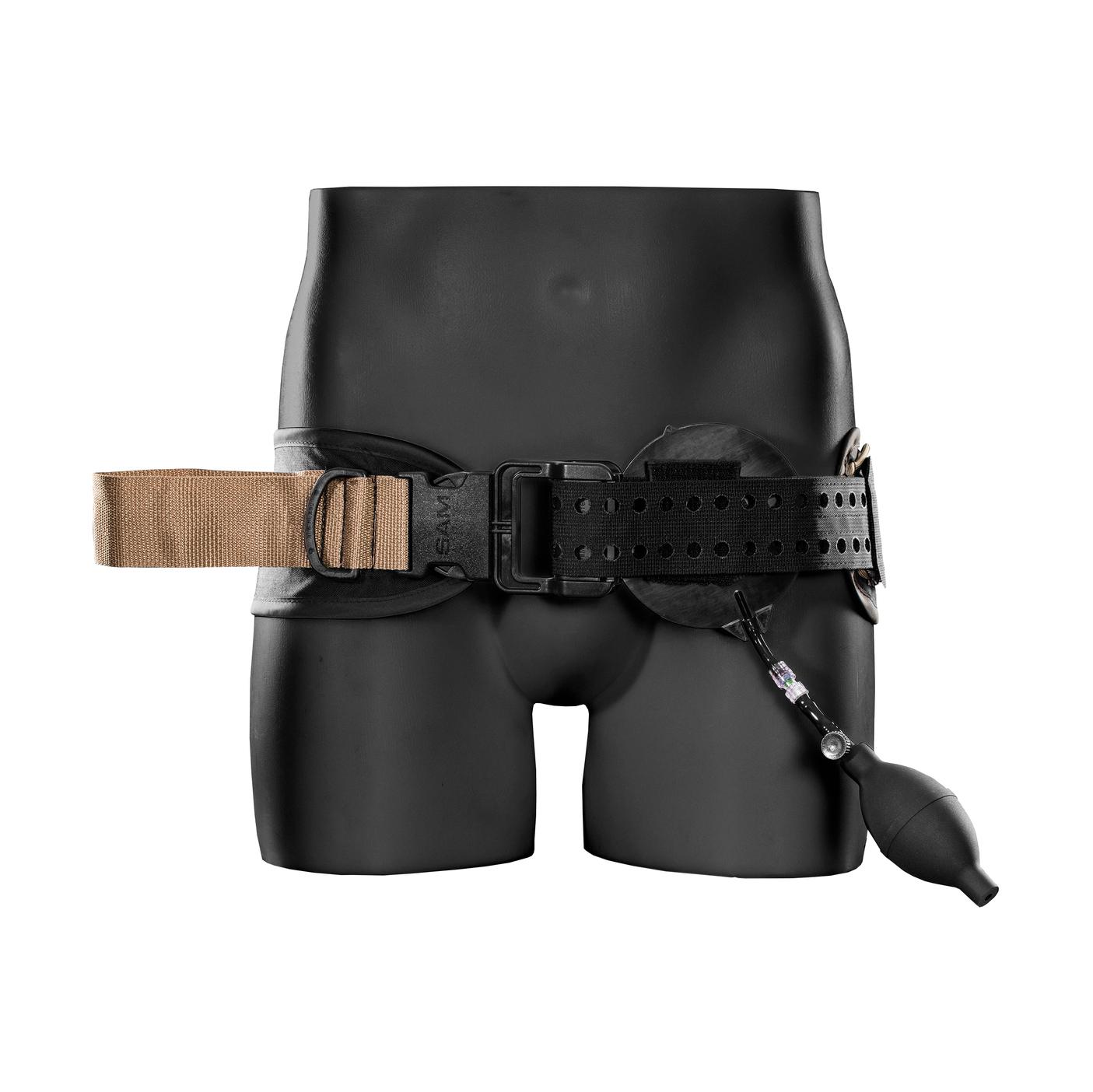 Ein schwarzer Torso trägt ein beigefarbenes SAM® Junctional Tourniquet mit schwarzem Verschluss, das in vier Schritten schnell anwendbar ist und eine Luftdruckpumpe besitzt.