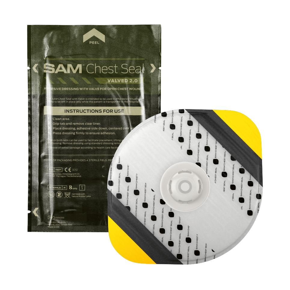 SAM® Chest Seal Valved 2.0 mit Ventil in Originalverpackung und einzelnem runden Verband mit schwarz-gelbem Streifenmuster und weißem Zentrum