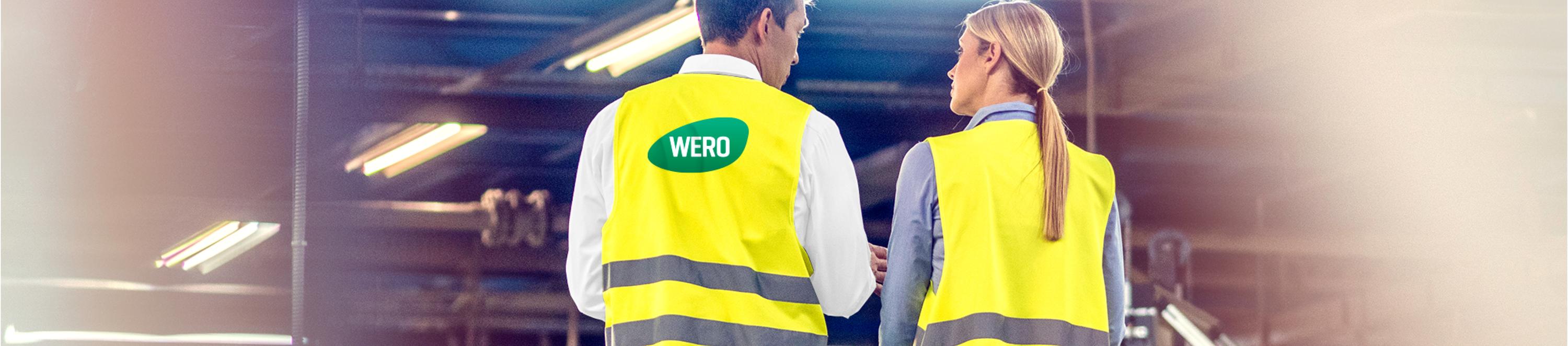 Banner Zwei WERO Mitarbeitende stehen mit dem Rücken zur Kamera. Sie tragen neongelbe Warnwesten