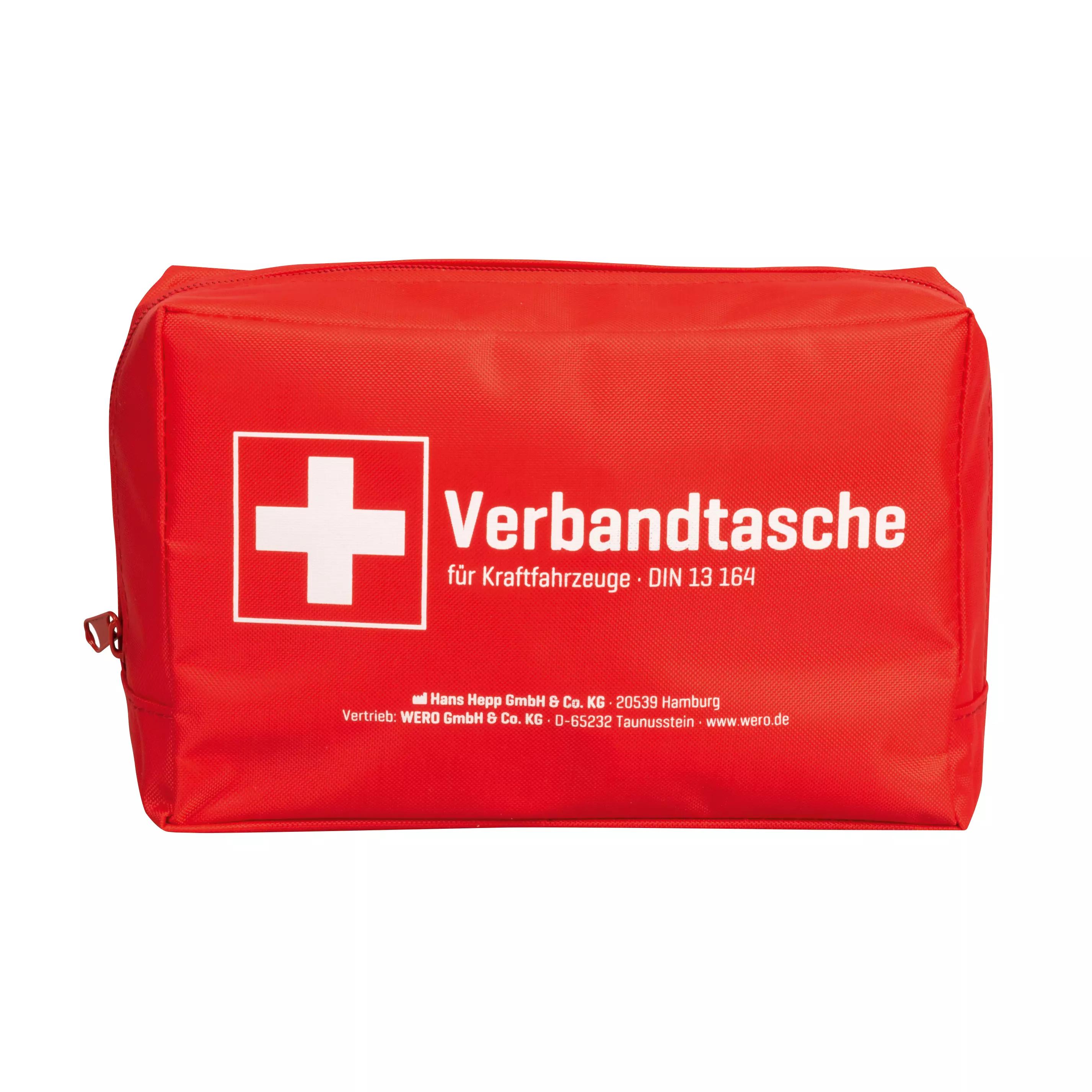 Ein rechteckige Verbandtasche Auto (KFZ) DIN 13164:2022-02 aus robustem Nylon mit weißem Kreuz, Kompaktheit und Reißverschluss liegt geschlossen.