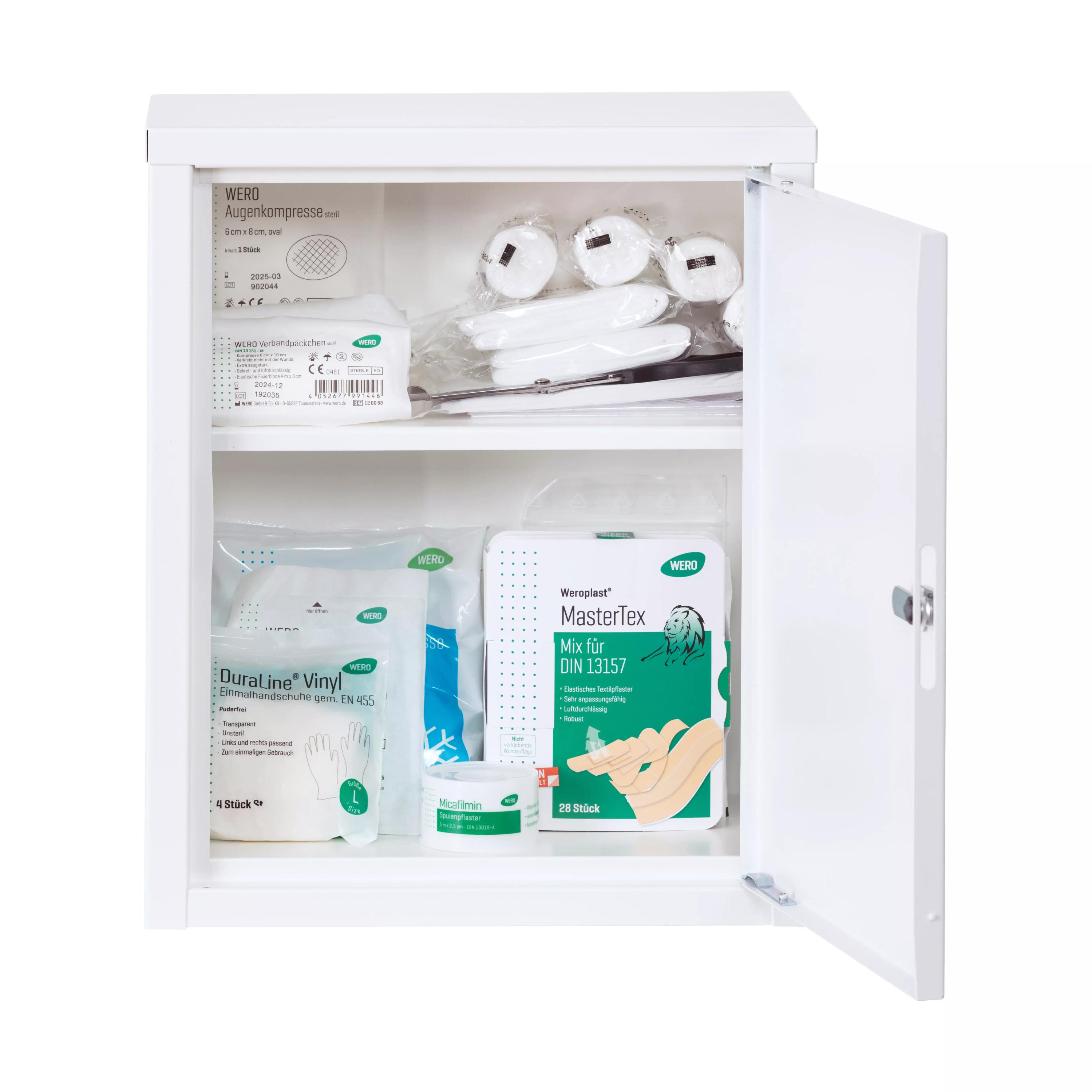 Weißer WERO Verbandschrank MiniDuo 20 mit leicht geöffneter Tür, feststehendem Zwischenboden und auf zwei Ebenen sortiertem Erste-Hilfe-Material.