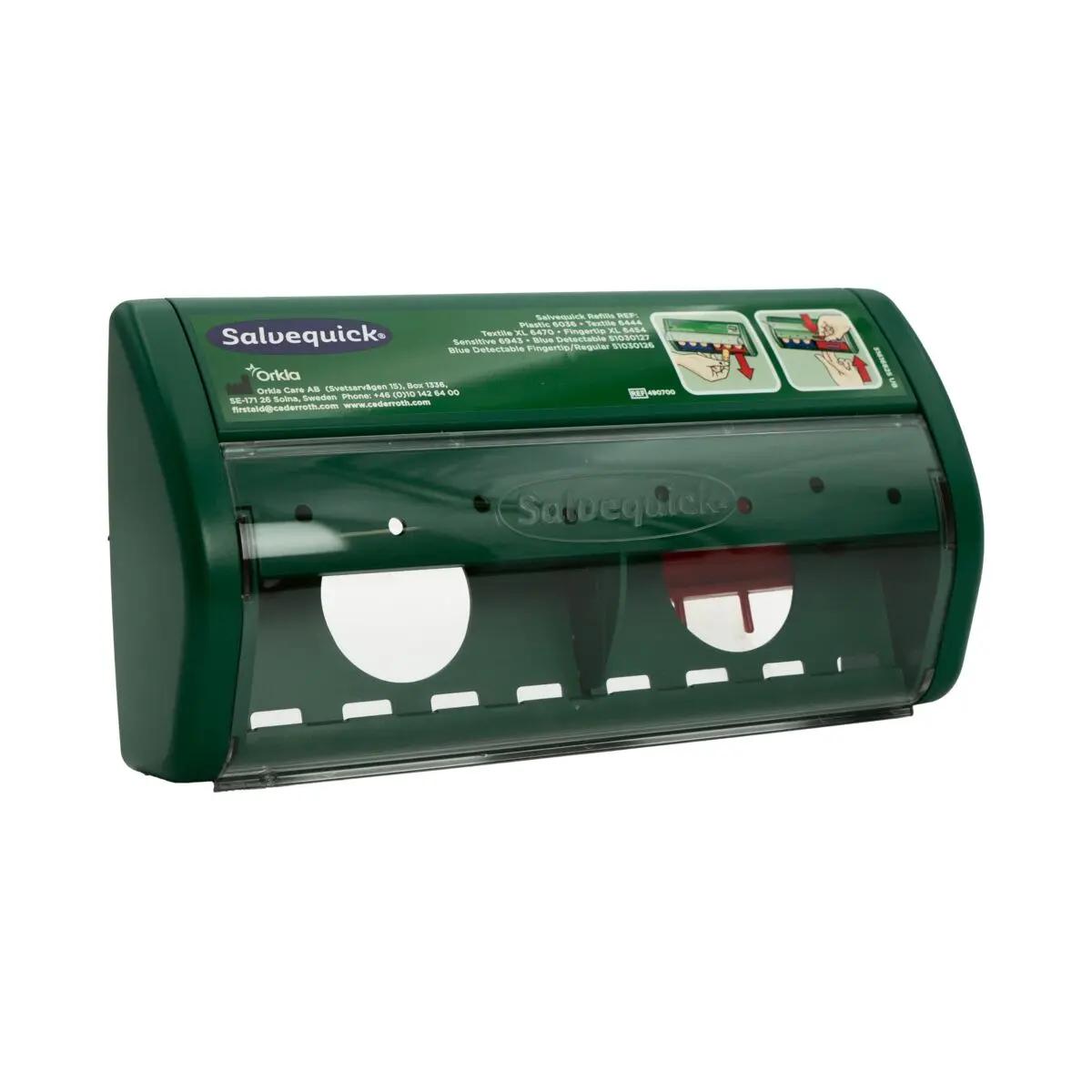 Der Salvequick® Sofortpflaster-Spender PRO, leer, in dunkelgrünem Kunststoffgehäuse mit transparenten Klappen und zwei runden Öffnungen, ist geöffnet.