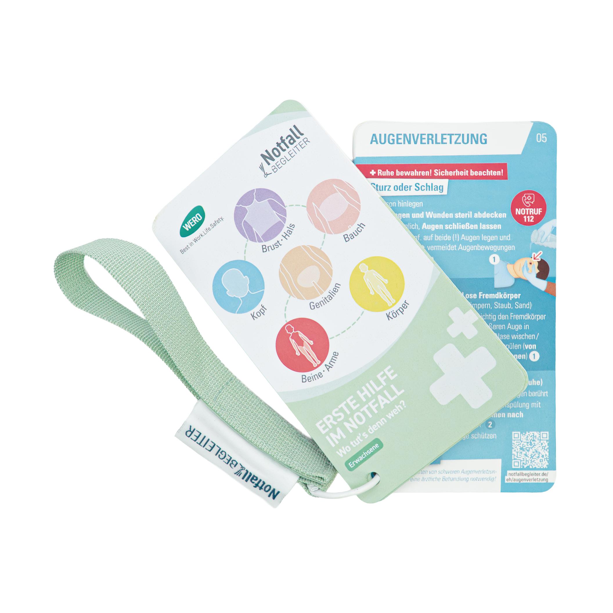 Weiße Erste-Hilfe-Karte mit grünem Kreuz, gelbem "AKA Medica"-Schriftzug und grünem Lanyard, beidseitig mit Unfall- und Erste-Hilfe-Anweisungen.
