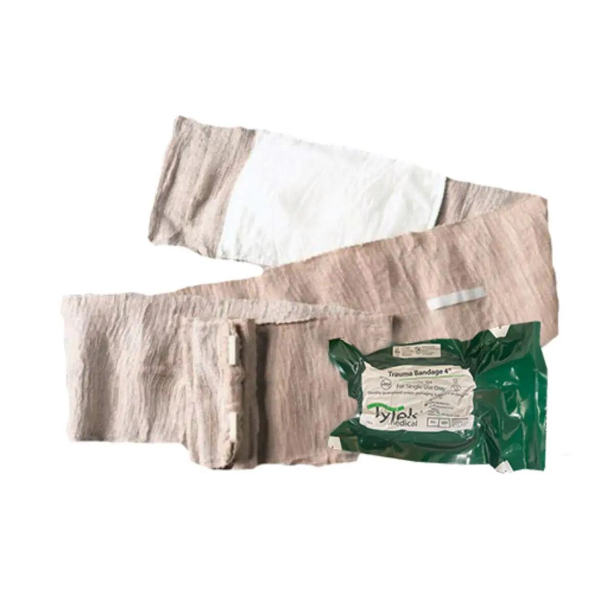 Tytek® Trauma Bandage - 10 cm, aufgerollt mit integrierter nicht haftender Wundauflage, Klettstreifen und Verschlussklammer, neben grüner Verpackung.